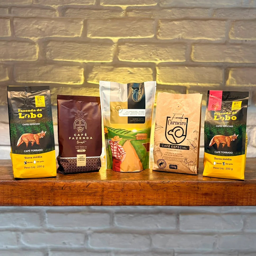 Cinco pacotes de café especial de produtores do Sul de Minas sobre uma bancada de madeira